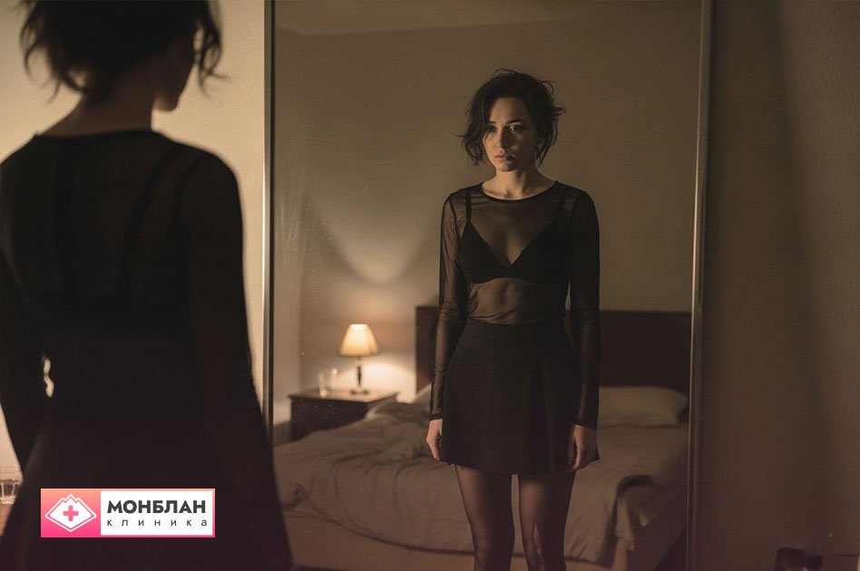 Девушка смотрит на себя в зеркало